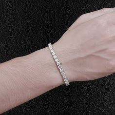 Dazzle your friends, with this stunning moissanite tennis bracelet. The stones are moissanite, which shine even brighter than diamonds, and although it ain't cheap, it costs a tiny fraction of it's diamond equivalent. You can literally look like a millionaire, without having to be one! The two stone sizes (4mm & 5mm) we have are the sizes men wear. Smaller and they are too dainty. Larger and they again take on a more feminine look. Of these two sizes, most guys go for the 5mm. They are set in a Gift Moissanite Tennis Bracelet In White, Moissanite Diamond Bracelet With Prong Setting, Diamond White Moissanite Tennis Bracelet With Brilliant Cut, Moissanite Tennis Bracelet Gift, Moissanite Jubilee Bracelet With Round Cut, White Moissanite Tennis Bracelet As Gift, Diamond White Moissanite Jubilee Tennis Bracelet, White Moissanite Jubilee Tennis Bracelet, Dazzling Moissanite Tennis Bracelet In Diamond White