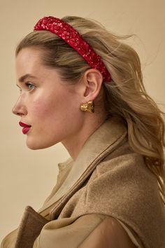 a woman with long hair wearing a red headband and looking off to the side