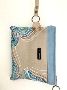 a purse hanging on the wall with a keychain attached to it's side