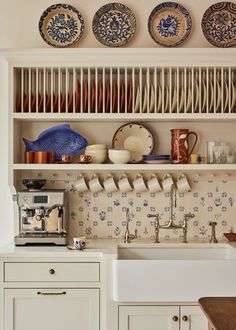 the kitchen is clean and ready to be used for cooking or baking, with dishes hanging above the sink