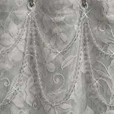 closeup of white lace with beads hanging from it's back end and side