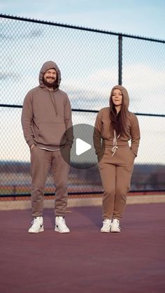 a man and woman standing next to each other in front of a fence with the words,