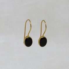 Black Onyx and 18k Gold Vermeil Oval Drop Earrings Natural cabochon black onyx gemstones in a simple 18k gold plated silver setting, with a hook fitting. Simple drop earrings perfect for everyday wear.  Dimensions (approx): * Length: 2.2cm including hook * Turquoise: 7mm x 9mm Materials: * 18k Gold Plated Silver * Black Onyx Beyond Biasa creates unique jewellery that is inspired by antique and tribal designs from around the globe. All of our pieces are handmade so please allow for slight variati Elegant Black Cabochon Earrings, Classic Round Onyx Earrings, Classic Onyx Round Earrings, Classic Black Oval Earrings, Classic Oval Cabochon Gemstone Earrings, Black Oval Earrings For Formal Occasions, Elegant Black Oval Earrings, Classic Black Earrings With Polished Finish, Formal Onyx Gemstone Earrings