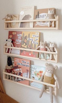 two wooden shelves filled with books and stuffed animals on top of each shelf in a child's room