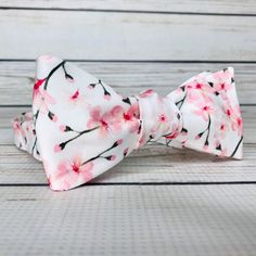 "Pale pink cherry blossoms on white cotton sateen. Because of the handmade nature of these bowties they can vary in size ever so slightly but on average the bow measures 5 inches by 2 inches when tied. hand wash/ spot wash only The self-tied option will be made in the style pictured. The pre-tied option will have the addition of a hook in the back, and the bow will be stitched in the tied position. RETURNS: I accept returns on items in original, unused condition. You will receive a refund for th White Bow Tie For Spring, White Ties For Spring Gift, White Ties As Spring Gifts, Adjustable White Tie With Satin Bow, Spring Gift White Ties, White Adjustable Tie With Satin Bow, White Satin Bow Tie Adjustable, White Adjustable Satin Bow Tie, Elegant Bow Tie For Spring Gifts