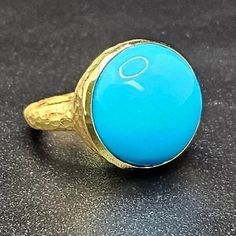 14k solid yellow gold hammered ring with 13.5 ct. 16.0 mm round shape natural AAA turquoise. This item can also be ordered in rose or white gold with different color gemstones such as, green tourmaline, pink tourmaline, rutilated quartz, onyx, labradorite, white agate, all colors of chalcedony and aquamarine, please contact for a quote as each gemstone varies in price. I am a manufacturer of fine jewelry for over thirty years, loyalty and customer satisfaction have always been my ultimate goals. Gold Turquoise Ring With Gemstone, Handmade Yellow Gold Turquoise Ring, Handmade Turquoise Ring In Yellow Gold, Elegant Gold Turquoise Round Ring, 14k Gold Turquoise Round Ring, 14k Gold Turquoise Ring, Hammered Ring, Hammered Rings, White Agate