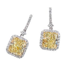 A stunning pair of dangle earrings featuring 6.03 carats of fancy yellow diamonds, accented by 0.81 carats of diamonds, set in 18 karat two tone gold. Luxury Yellow Diamond Drop Earrings, Luxury Yellow Diamond Earrings For Wedding, Elegant Yellow Diamond Earrings, Formal Yellow Diamond Earrings, Formal Yellow Diamond Cut Earrings, Yellow Diamond Earrings For Formal Occasions, Formal Yellow Diamond Earrings With Diamond Cut, Luxury Yellow Diamond Cut Earrings, Wedding Yellow Diamond Earrings With Accents