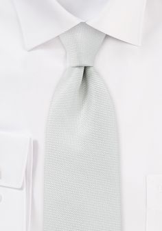 You can upgrade your formal attire to the next level. One of our lightest ivory-coloured neckties is made from a blend of white and ivory coloured yarns. It is the ideal option for people who don't want a flashy, white necktie but also don't want an ivory tie that is traditionally worn by grooms and at weddings. We recommend wearing this item with a solid white shirt, a black or charcoal suit, and a pair of mother-of-pearl cufflinks. White Standard Tie For Work, White Business Ties, Luxury White Formal Ties, White Standard Tie For Business, Semi-formal White Suit With Hidden Button Closure, Charcoal Suit, Pearl Cufflinks, Formal Attire, Ivory Color