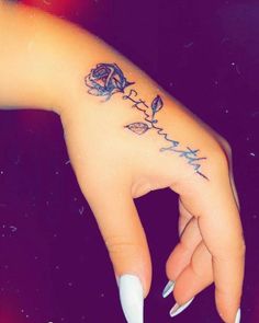 a woman's hand with a rose tattoo on it and the word love written in cursive writing