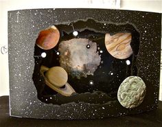 the solar system is made out of black paper and has planets on it's side