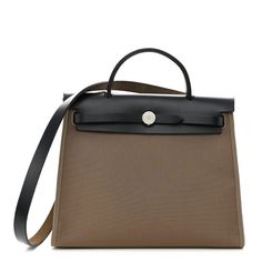 This is an authentic HERMES Vache Hunter Toile Herbag Zip 31 PM in Etoupe and Ebene.This stylish shoulder bag is crafted of sturdy taupe canvas and features a black leather top crest with a matching top handle, shoulder strap and a rear zipper pocket. The flap secures with double straps, complemented with polished palladium silver hardware. This opens to a brown canvas interior and includes a removable zipper pouch. Herbag Hermes, Black Leather Top, Stylish Shoulder Bag, Brown Canvas, Matching Top, Leather Top, Silver Hardware, Zipper Pouch, Top Handle