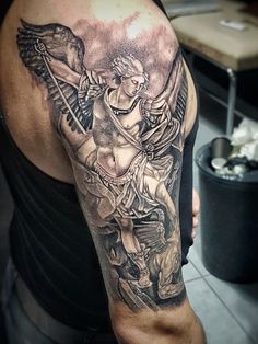 a man with a black and grey tattoo on his arm is holding a cupid