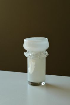 a glass jar filled with white liquid on top of a table