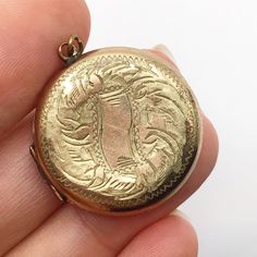 Lovely, rolled gold, locket from around the early 1900s judging by the style. It has old photos from the 1940s but the locket looks older. The gold finish on this locket has some wear, particularly on the back. It measures 2.7 cm ( 1.1 inch ) across. Antique Gold Locket Necklace Stamped 14k, Antique Medallion Locket Necklace Stamped 14k, Victorian Round Locket Necklace Stamped 14k, Antique Etched Locket Necklace For Memorial, Historical Gold Jewelry For Weddings, Antique Engraved Yellow Gold Locket Necklace, Vintage Gold Locket Necklace Stamped 14k, Antique Gold Hallmarked Locket Necklace, Gold Etched Victorian Locket Necklace