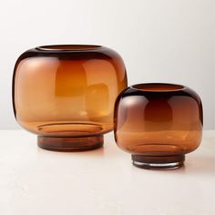 two brown glass vases sitting next to each other