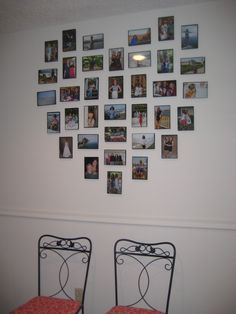 two red chairs sitting in front of a white wall with pictures on the wall above them