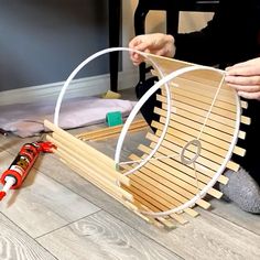 a person sitting on the floor with a wooden slatted object in front of them