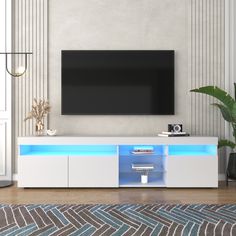 a flat screen tv mounted to the side of a white entertainment center in a living room