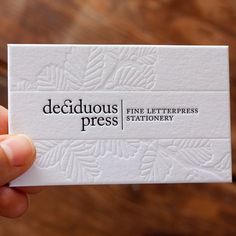 a person holding up a business card with the word dedicious press on it