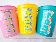 three brightly colored plastic cups with the word boo on them are sitting next to each other