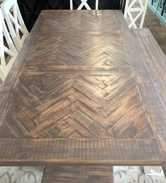 a wooden table with white chairs around it