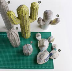 paper mache cactuses are sitting on a cutting board next to some other items