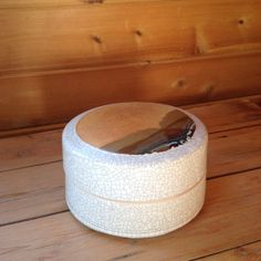 a wooden table topped with a white box filled with scissors on top of a wooden floor