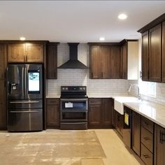 an empty kitchen with wooden cabinets and stainless steel appliances in the middle of the room