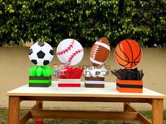 an outdoor table with sports themed items on it, including paper plates and cupcakes