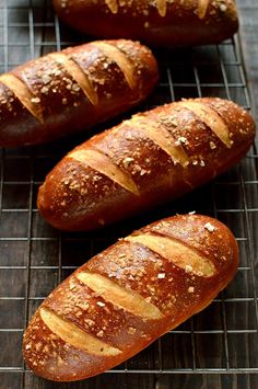 three loaves of bread sitting on top of a cooling rack