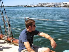 a man sitting on top of a boat in the water