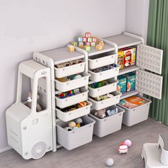 a toy storage unit with bins and containers on the floor in front of it