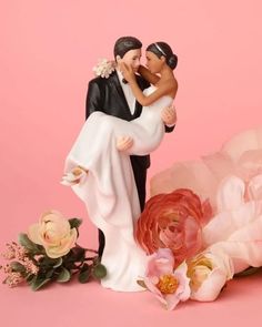 a bride and groom figurine next to flowers on a pink background with the caption wedding collectibles love is in everything we do