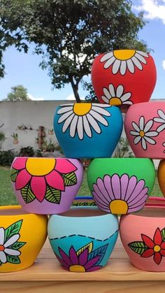 many colorful bowls are stacked on top of each other in the shape of flower pots