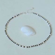 This unique piece features natural freshwater pearls in varying sizes, beautifully complemented by natural black agate tubes. The minimalist design exudes sophistication and versatility, making it a timeless addition to any jewelry collection. Whether worn alone or layered, this necklace adds a touch of effortless beauty to any outfit. Metal: Recycled Sterling Silver Plated On Brass Pearl: Natural Pearls Gemstone: Black Onyx Chain Length: 400-450mm Weight: 8.5g Black And White Pearl Necklace, Dark Tide, Necklaces Pearl, Edison Pearls, Effortless Beauty, White Pearl Necklace, Gemstone Beaded Necklace, Tiger Eye Stone, Black Agate