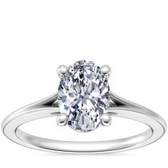 an oval cut diamond engagement ring with three clawed shans on the shoulders and sides