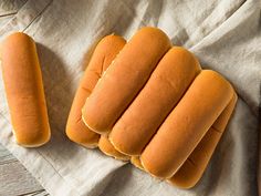 four hot dogs sitting on top of a wooden table