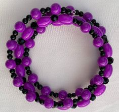 This bracelet is comprised of various shapes of hot purple beads along with various shapes and sizes of shiny black beads.  This pretty bracelet is made with spiraled memory wire so it will fit everyone!  It makes a great gift because you don't have to know someone's wrist size for it to be the perfect fit.    The matching earrings in picture #6 can be found at this link: https://www.etsy.com/listing/1109337928/earrings-hot-purple-and-black-dangle The matching necklace in picture #7  is here: ht Purple Beaded Bracelets With Black Beads As A Gift, Purple And Black Jewelry, Adjustable Purple Bracelets With Black Beads, Adjustable Purple Bracelet With Black Beads, Purple And Black Bracelet, Cheap Purple Hand-strung Beaded Bracelets, Purple Hand-strung Stretch Bracelet, Gray Bracelet, Black Bracelets