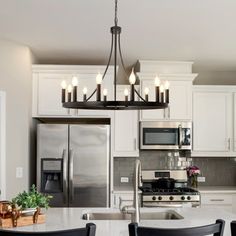 a kitchen with white cabinets and black chairs