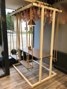 a room that has some kind of swing set in the corner with flowers on it