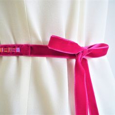 Add a gorgeous flash of colour to your wedding dress or bridesmaid dress with my handmade velvet sash belt. This luxurious bridal sash features hand-stitched beads on sumptuous velvet and is perfect for weddings with a bright jewel colour or geometric theme. I love the glass bugle beads used in this design and the subtle Art Deco feel. It works beautifully for brides and bridesmaids and is a lovely way to accentuate the waistline of your dress. The fuschia pink, deep magenta colour looks gorgeou Elegant Fitted Pink Sashes, Fitted Ribbon Sash For Wedding, Pink Bridal Belt With Sashes For Party, Pink Sashes Bridal Belt For Wedding, Elegant Pink Bridal Belt With Sashes, Fitted Bridal Belt With Ribbon For Wedding, Adjustable Ribbon Wedding Sashes, Fitted Embroidered Belt Sash For Wedding, Adjustable Bridesmaid Bridal Belt With Sashes