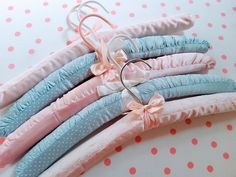 four pink, blue and white pillows are arranged on a polka dot tablecloth with ring holders in the middle