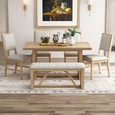 a dining room table with two chairs and a bench in front of it that has a painting on the wall