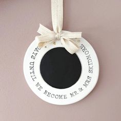 a white hanging ornament with a ribbon around it that says, we become mr and mrs