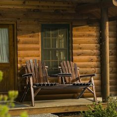 two wooden chairs sitting on top of a porch next to a log cabin with windows