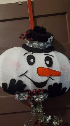 a snowman decoration hanging from the side of a door