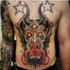 a man with tattoos on his chest has a demon mask and stars around it's neck