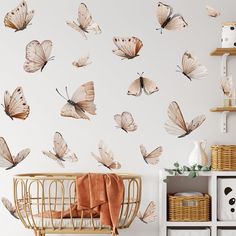 a baby crib in front of a white wall with lots of butterflies on it