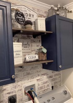 a washer and dryer in a small room with blue cabinets on the wall