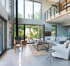 a living room filled with furniture and lots of windows